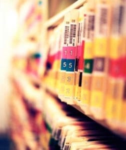 Close-up of dental patient charts showing forms and handwritten notes on a desk.