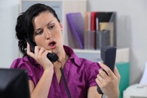 Dental office front desk staff assisting patients with appointments.
