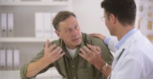 A dentist speaking with an angry patient.