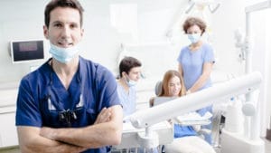 A man wearing a blue shirt in a dental consulting session.