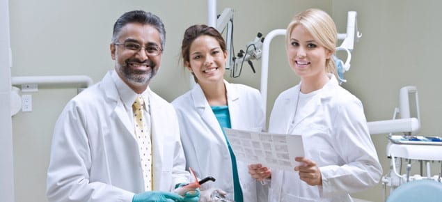 Group photo of dentists and team members smiling.