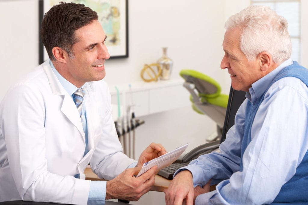 A patient making payment at the dental office reception desk.