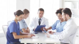 Dental staff attending a team meeting in a conference room.