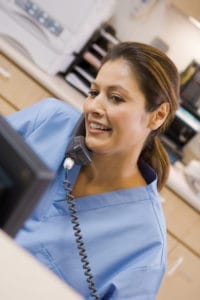 A dentist examining a patient's mouth in a dental office.