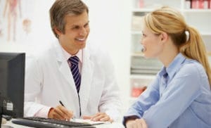 A dental consultant discussing treatment with a doctor and patient.