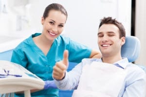 A dentist examining a patient in a dental chair.