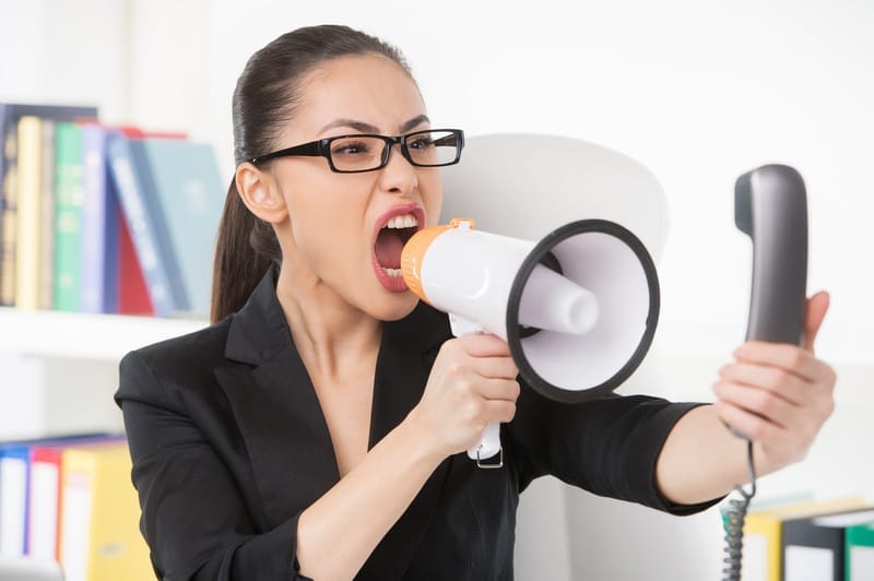 A receptionist yelling into a telephone using a megaphone.