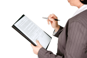 Official documents and forms arranged on a wooden desk surface.