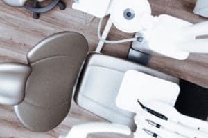 Modern dental operatory with patient chair, overhead light, and medical equipment.