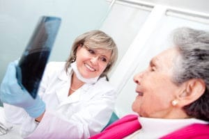 A dentist and patient engaged in conversation during a dental consultation.