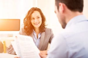 Stock photo of a smiling dental receptionist at the front desk.