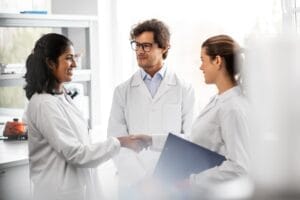 Two dental team members discussing treatment schedules at a computer in a modern office.