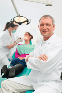 A dentist leading a discussion with a team of staff in a dental office.