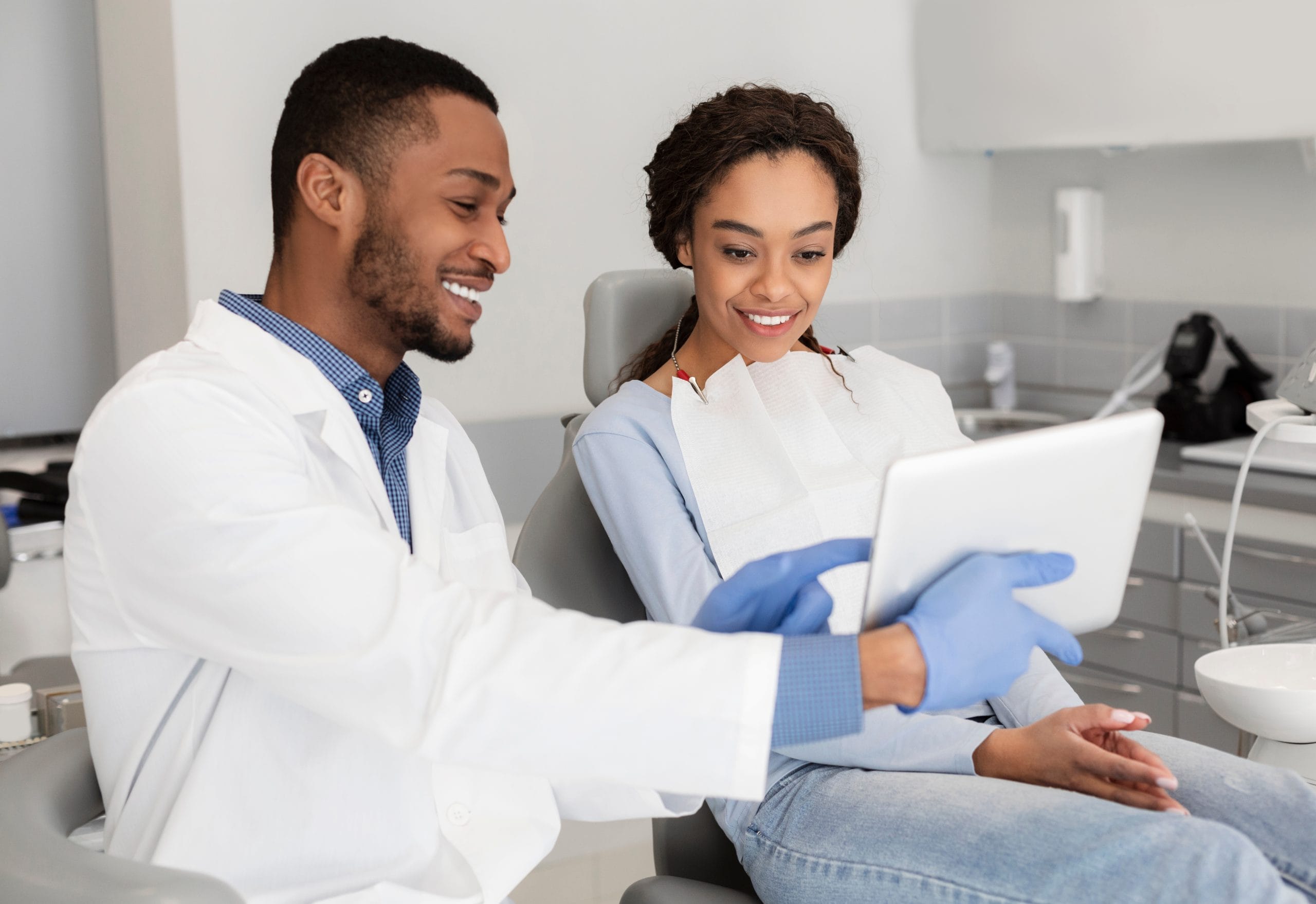 A dentist discussing a treatment plan with a patient in an examination room.