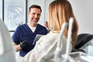 A dentist and patient discussing treatment options in a consultation room.