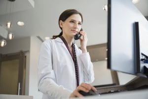 Dental receptionist handling incoming call.
