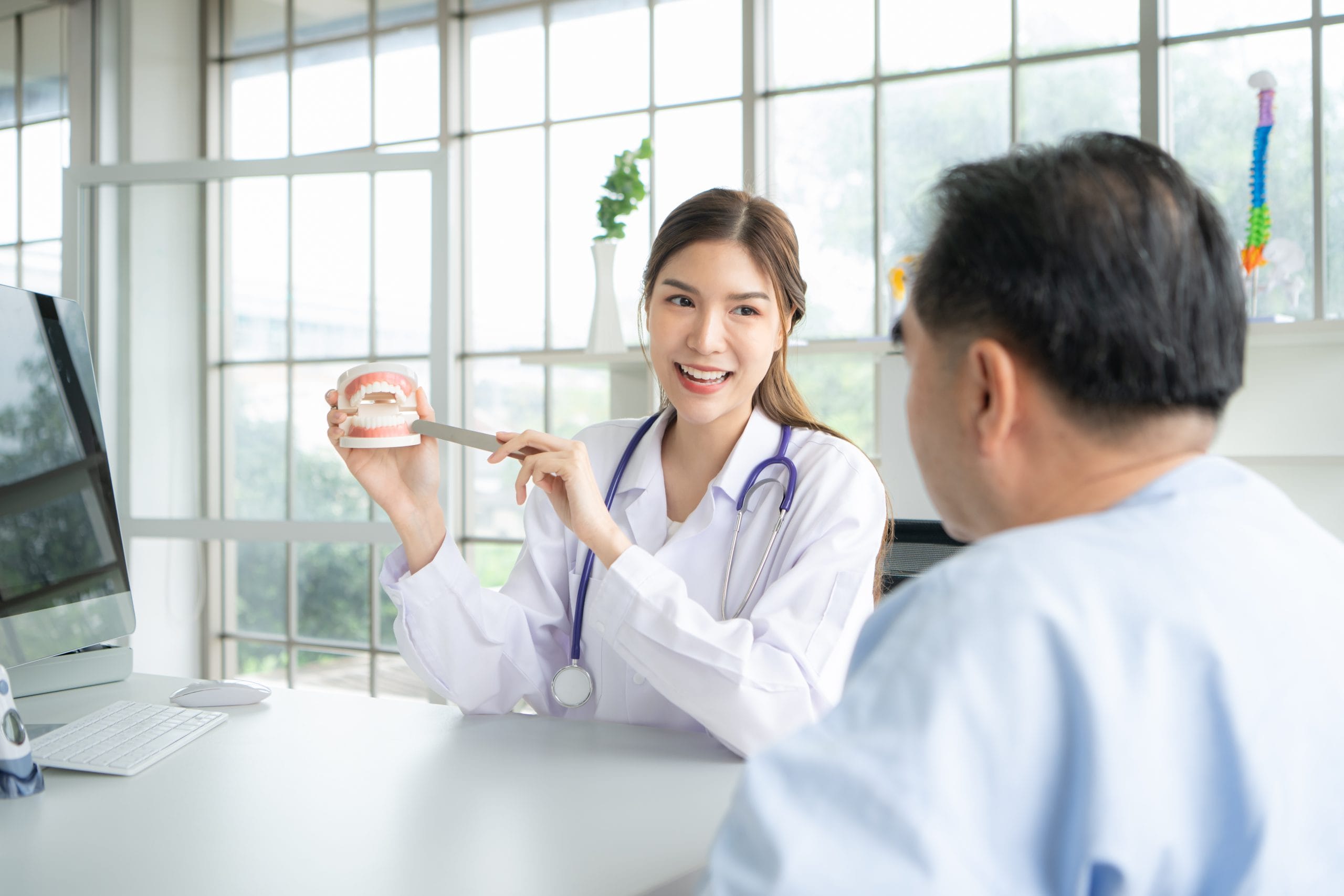 A doctor discussing treatment with a patient in an examination room.