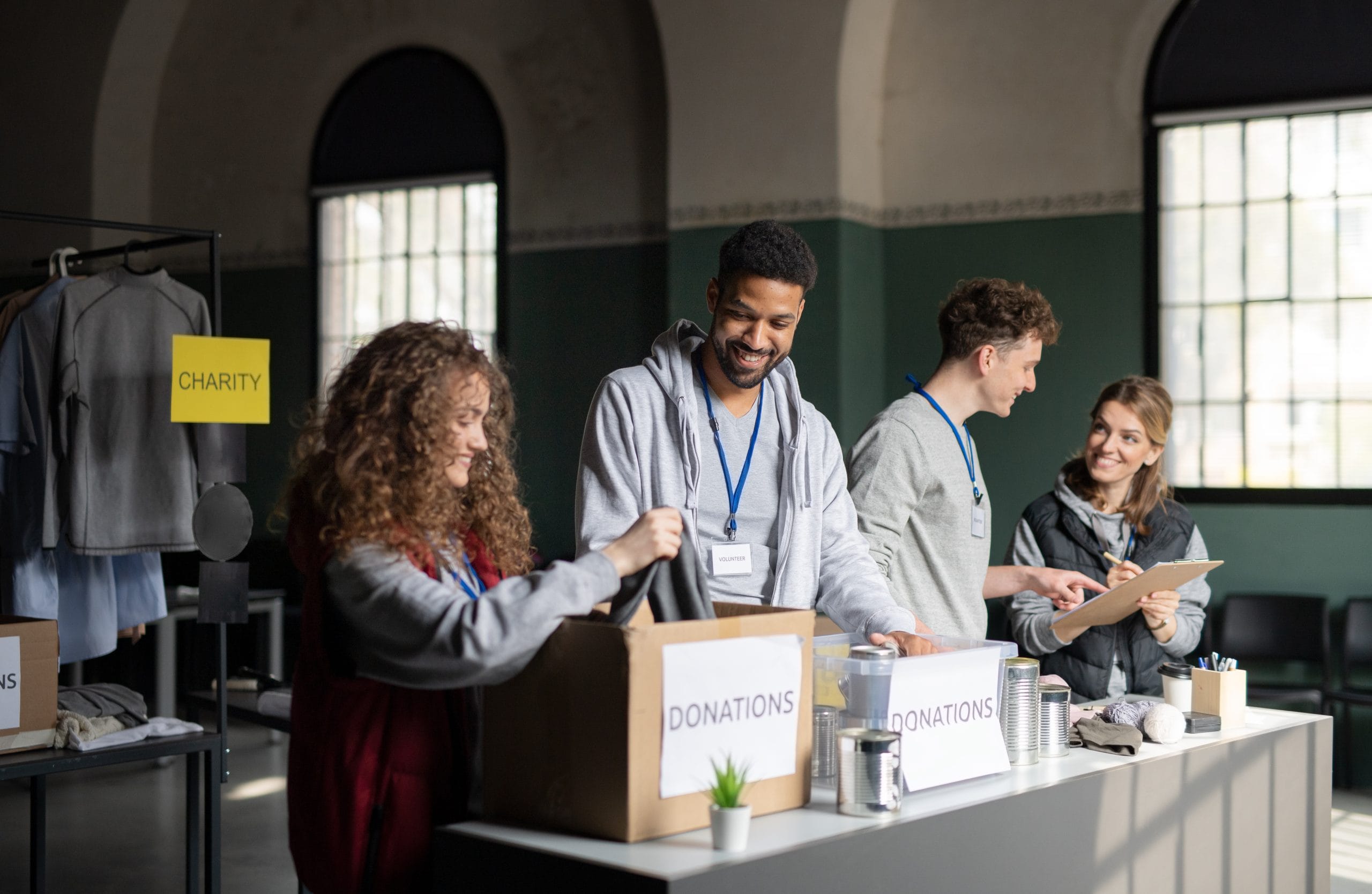 Men and women at a table with boxes that have the word donations on them.