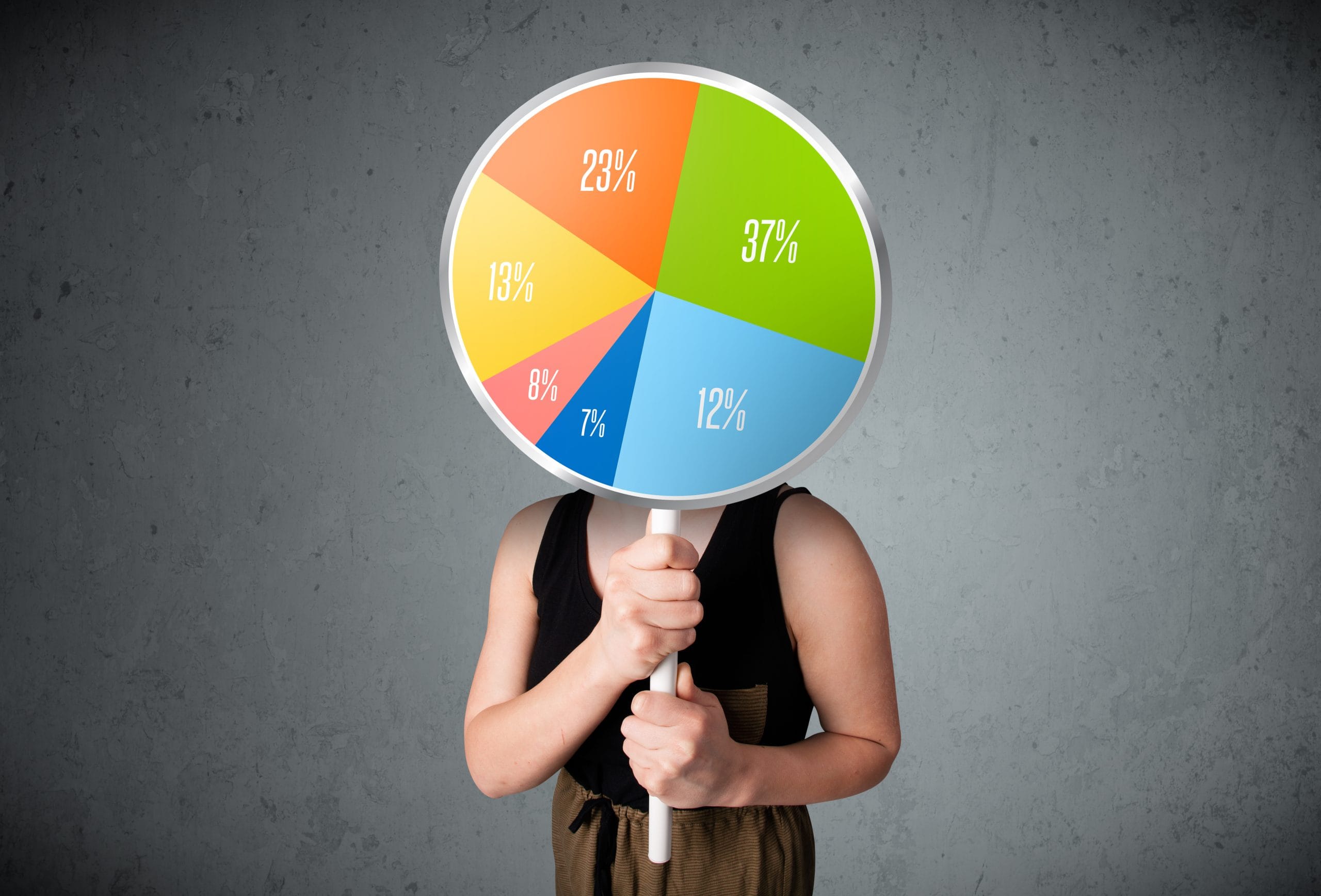 A young lady holding a colorful pie chart in front of her.